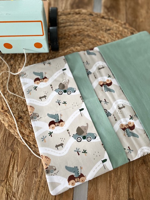 Geöffnete Wickeltasche in Türkis mit zwei Innenfächern und hellem Stoff im Fahrzeug-Designe