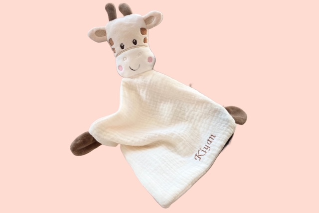 Schmusetuch Giraffe mit personalisierten Stickerei auf rosa Hintergrund.