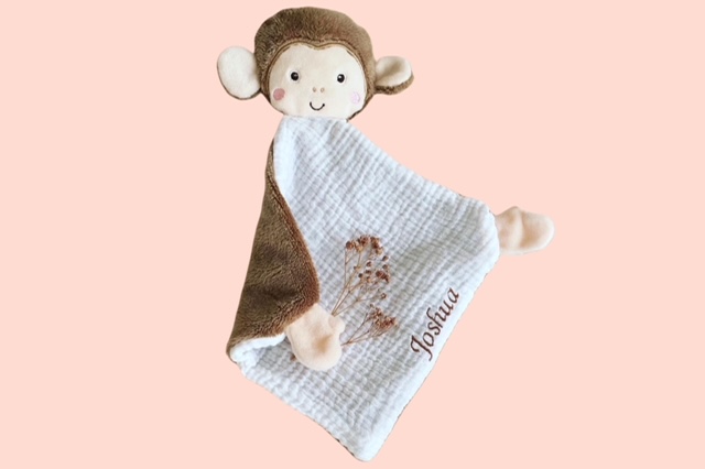 Schmusetuch Affe  mit weissem Musselin und brauner Rückseite, personalisiert mit dem Namen, auf rosa Hintergrund.