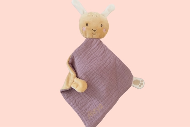 Personalisierbares Schmusetuch Hase in Altrosa mit bestickten Namen auf rosa Hintergrund.