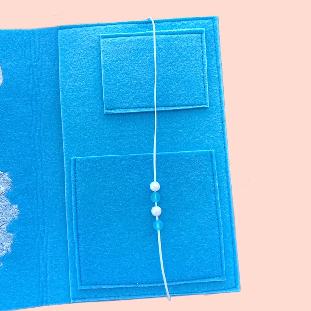 Innenansicht einer blauen Gesundheitshefthülle aus Filz mit Eineckfächern und Gummiband