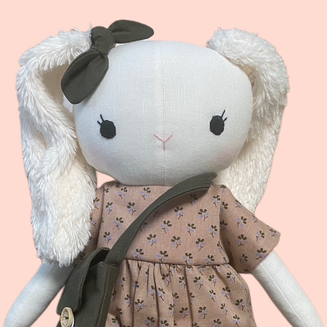 Detailaufnahme Stoffpuppe Hase mit besticktem Gesicht und weichen Schlappohren.