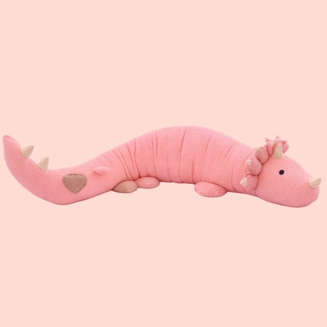 Rosa handgemachtes Dino-Kissen aus Stoff, längliches Kuscheltier in Dinosaurierform auf hellem Hintergrund.