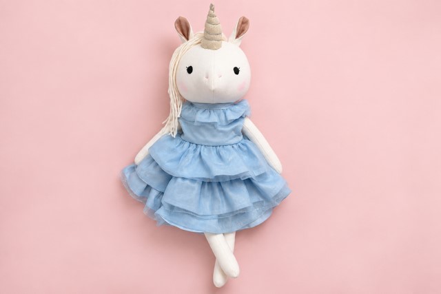 Handgemachtes Einhorn Lilliana mit hellblauen Prinzessinnenkleid auf zartrosa Hintergrund.