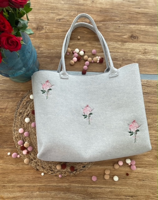 Fliztasche in beige mit einem Rosen Motiv.